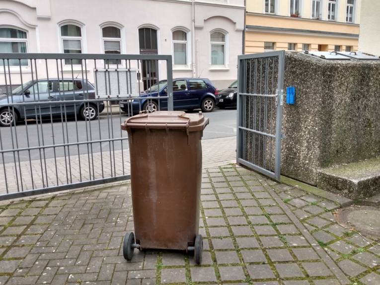 Eine Abfalltonne vor einem Ausgang